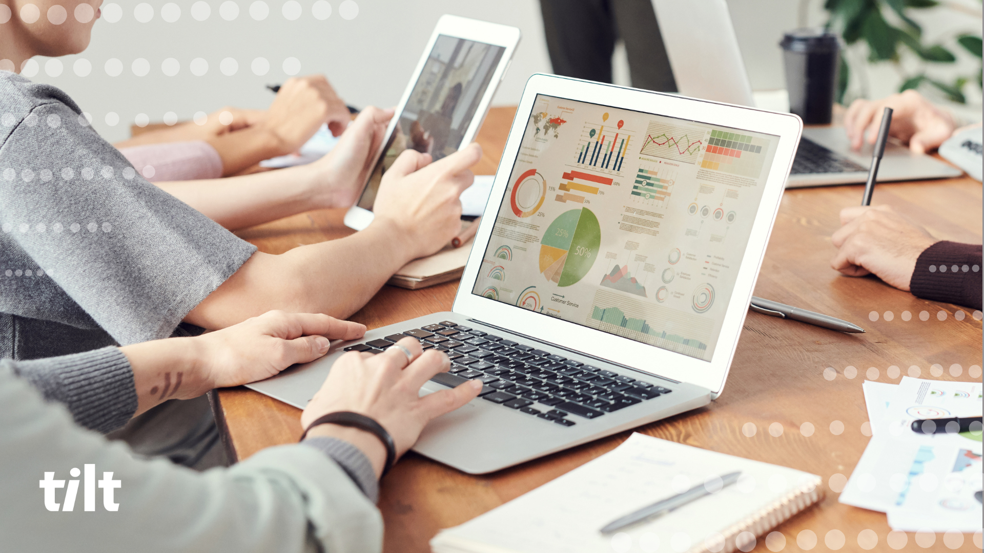 Image of workers at a desk on their laptops showing data